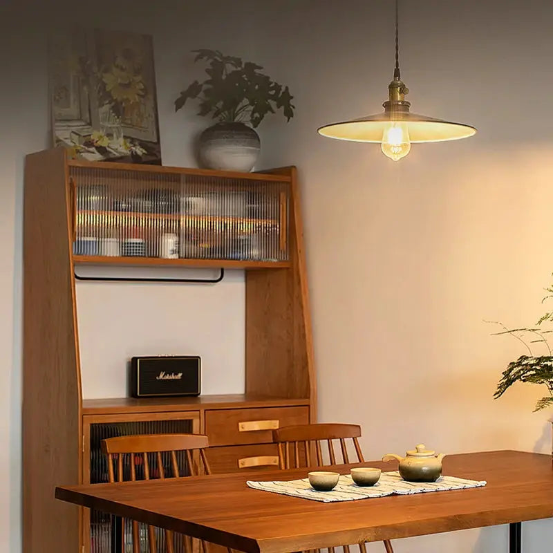 Retro Edison light bulb hanging pendant over a wooden dining table with a Marshall speaker.