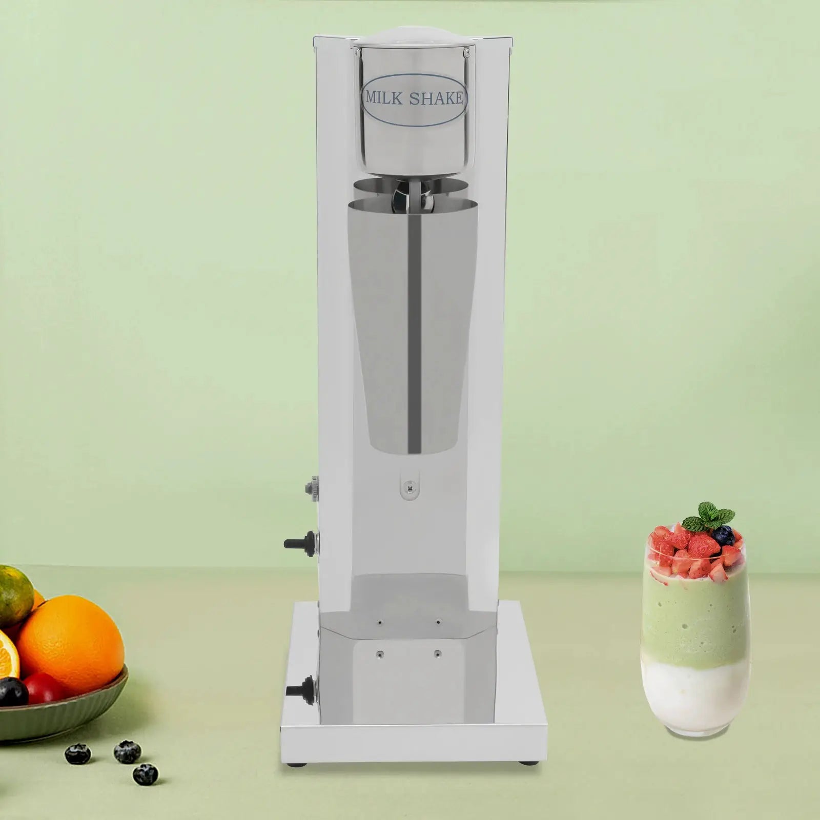 Commercial stainless steel milk shake machine with fruit bowl and smoothie glass (3 items) on mint backdrop