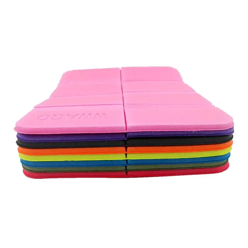 Foldable XPE foam outdoor mat by Simples Market, pink top with a stack of colorful moistureproof picnic cushions