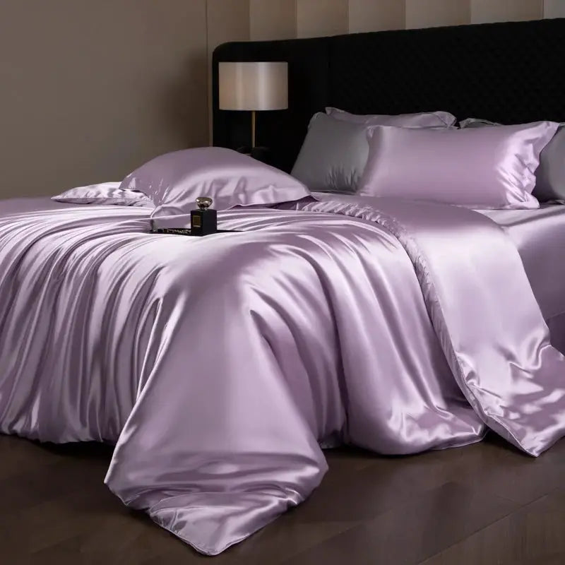 Silk bed sheet set by Simples Market in lavender satin with pillowcases on a bed