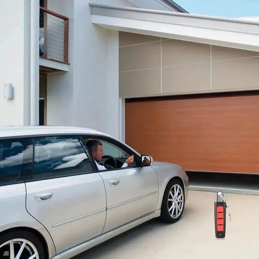 433MHz remote control duplicator by Simples Market; black remote with red buttons beside a silver car in the driveway