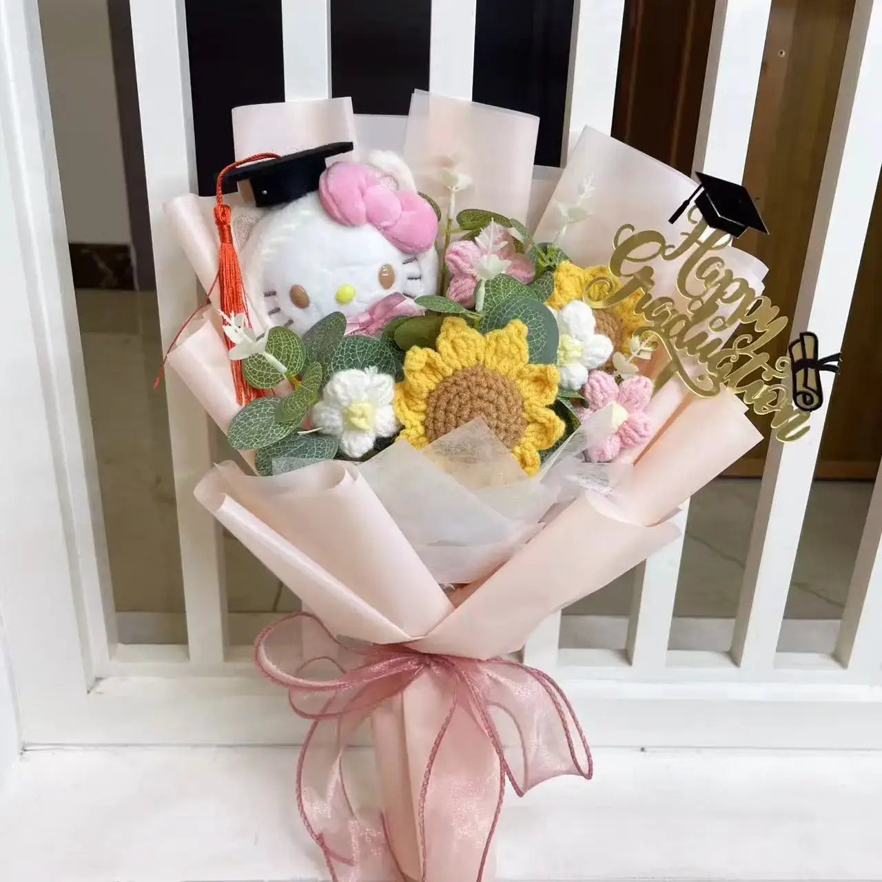 Stuffed plants bouquet featuring Hello Kitty plush, sunflowers, and pastel flowers in pink wrapping.