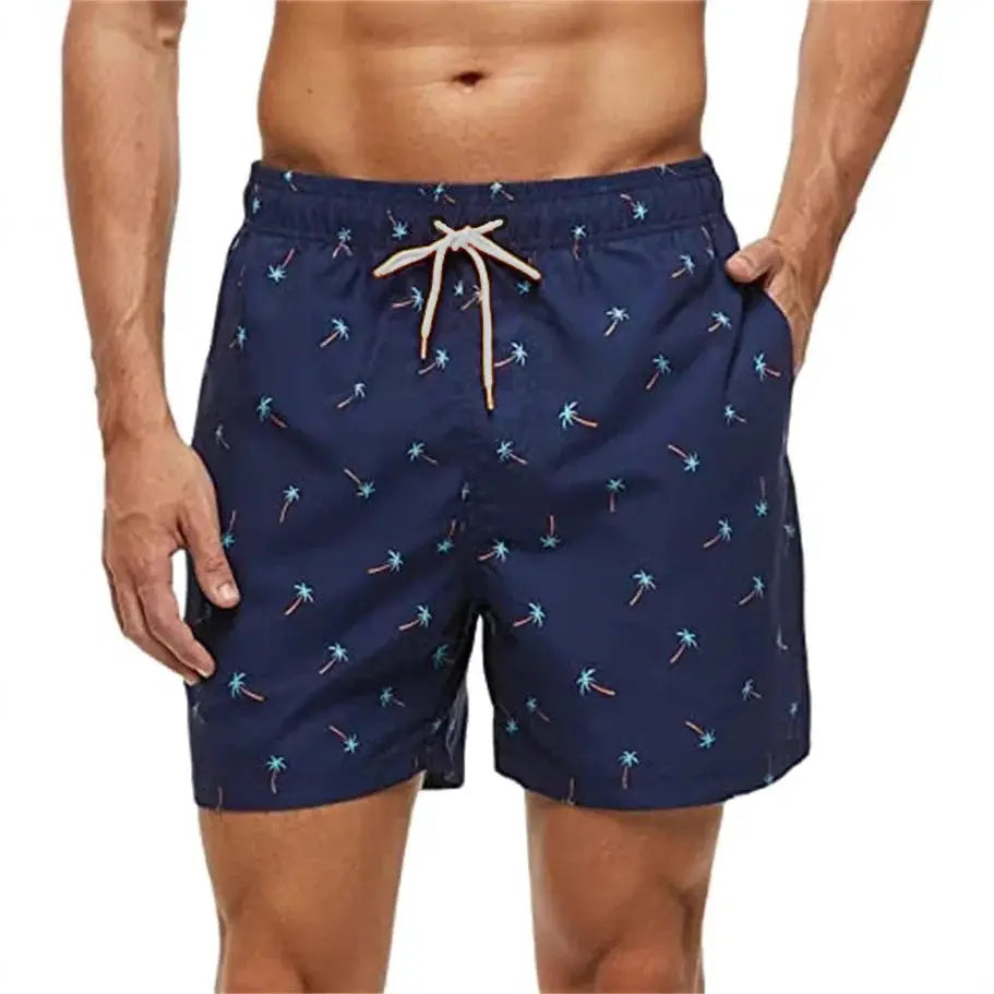 Men's navy palm-tree print swim shorts with white drawstring and side pockets.