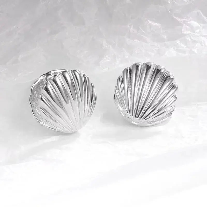 Two silver-tone shell-texture stud earrings, ocean-inspired, by Simples Market