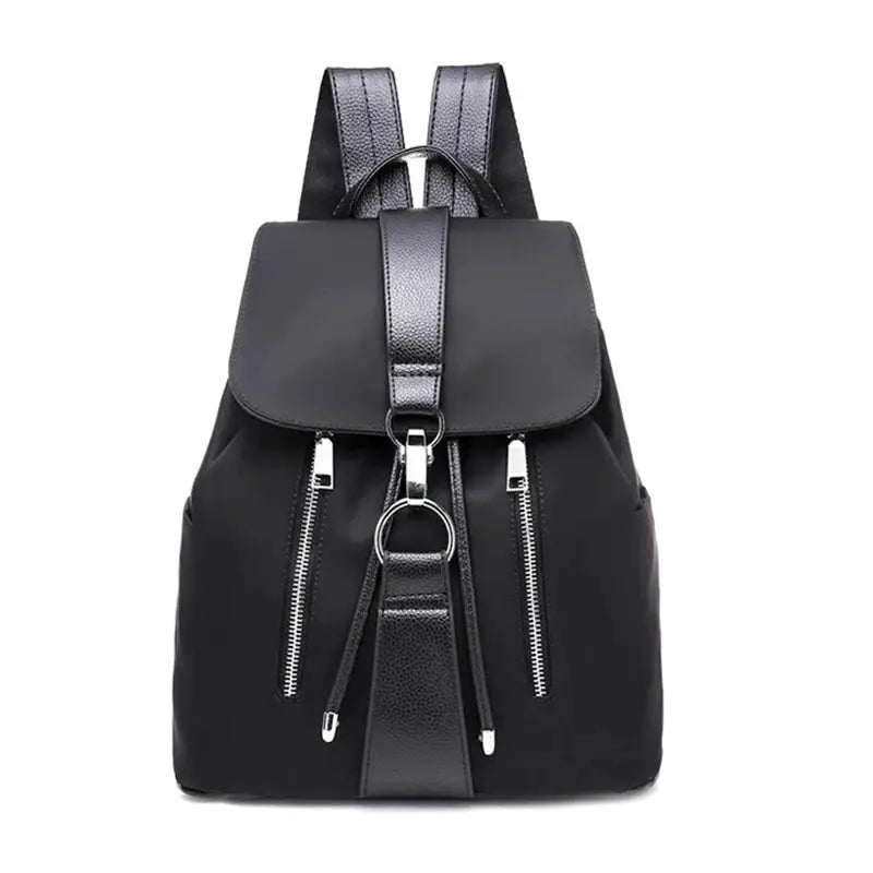 Black nylon women's backpack with front double zip pockets, top flap, and metal ring hardware.