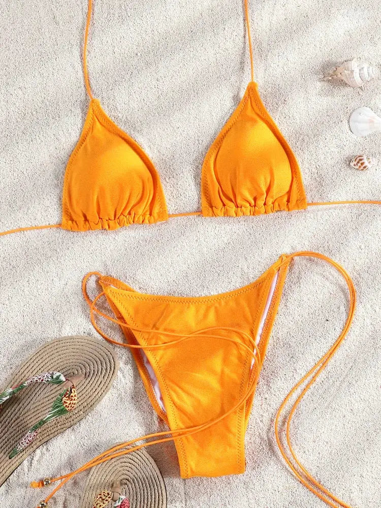Orange bikini set with triangle top and string-tie high-cut bottoms on sandy beach