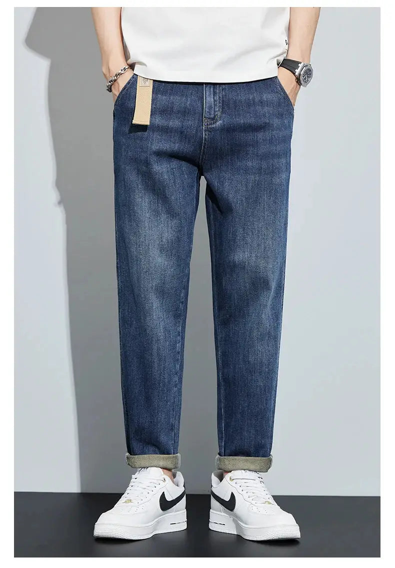 Men's dark blue denim jeans, loose straight fit with cuffed hems.