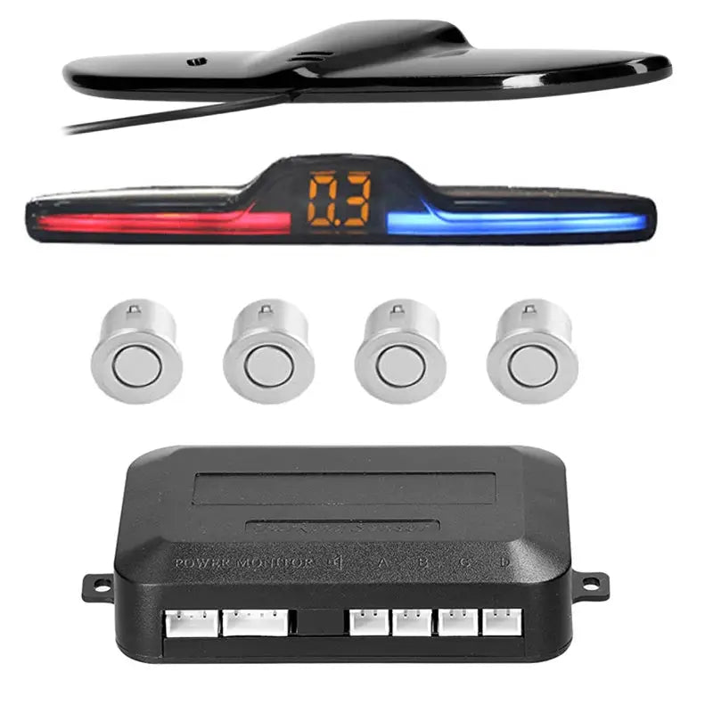 Car reverse radar kit by Simples Market with four silver sensors, LED distance display, and black control module.