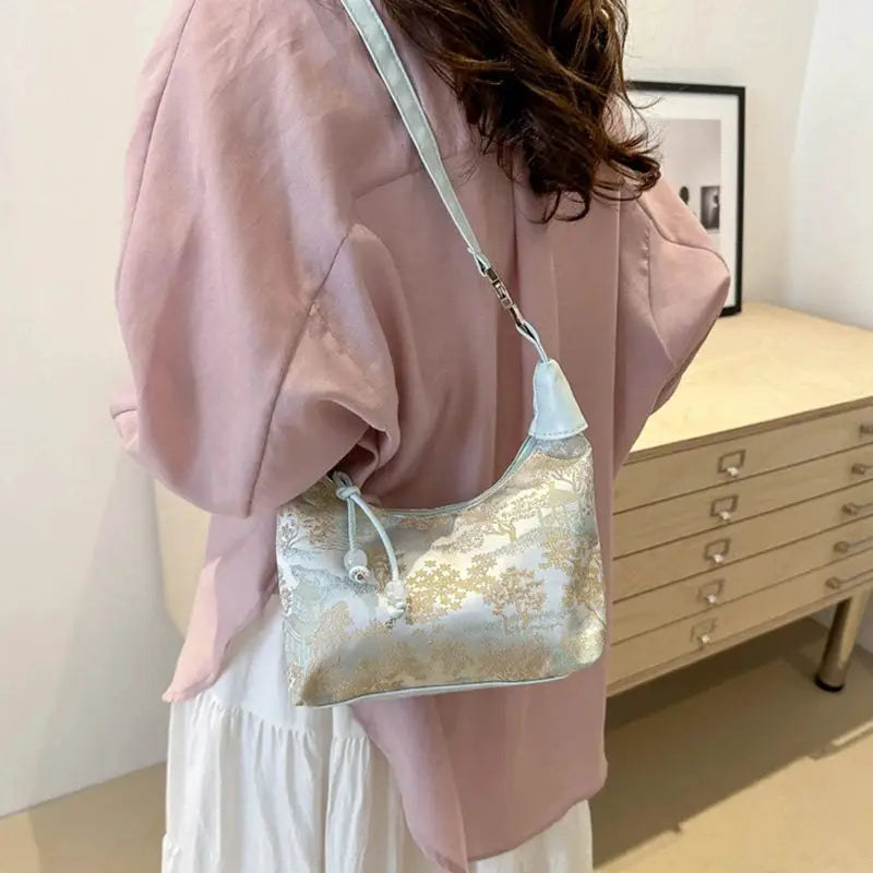 Ladies crossbody handbag with pale blue floral brocade embroidery, light blue strap and pearl tassel