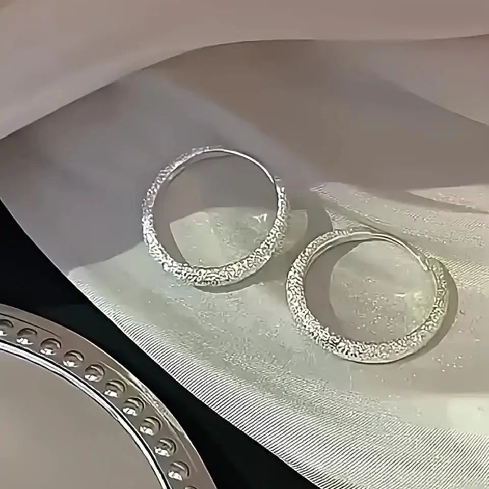 Pair of silvery frosted circle hoop earrings with sparkling texture for women