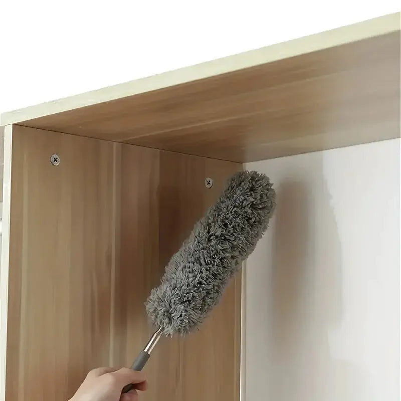 Cleaning duster with gray microfiber head on a handle for gaps and hard-to-reach areas.