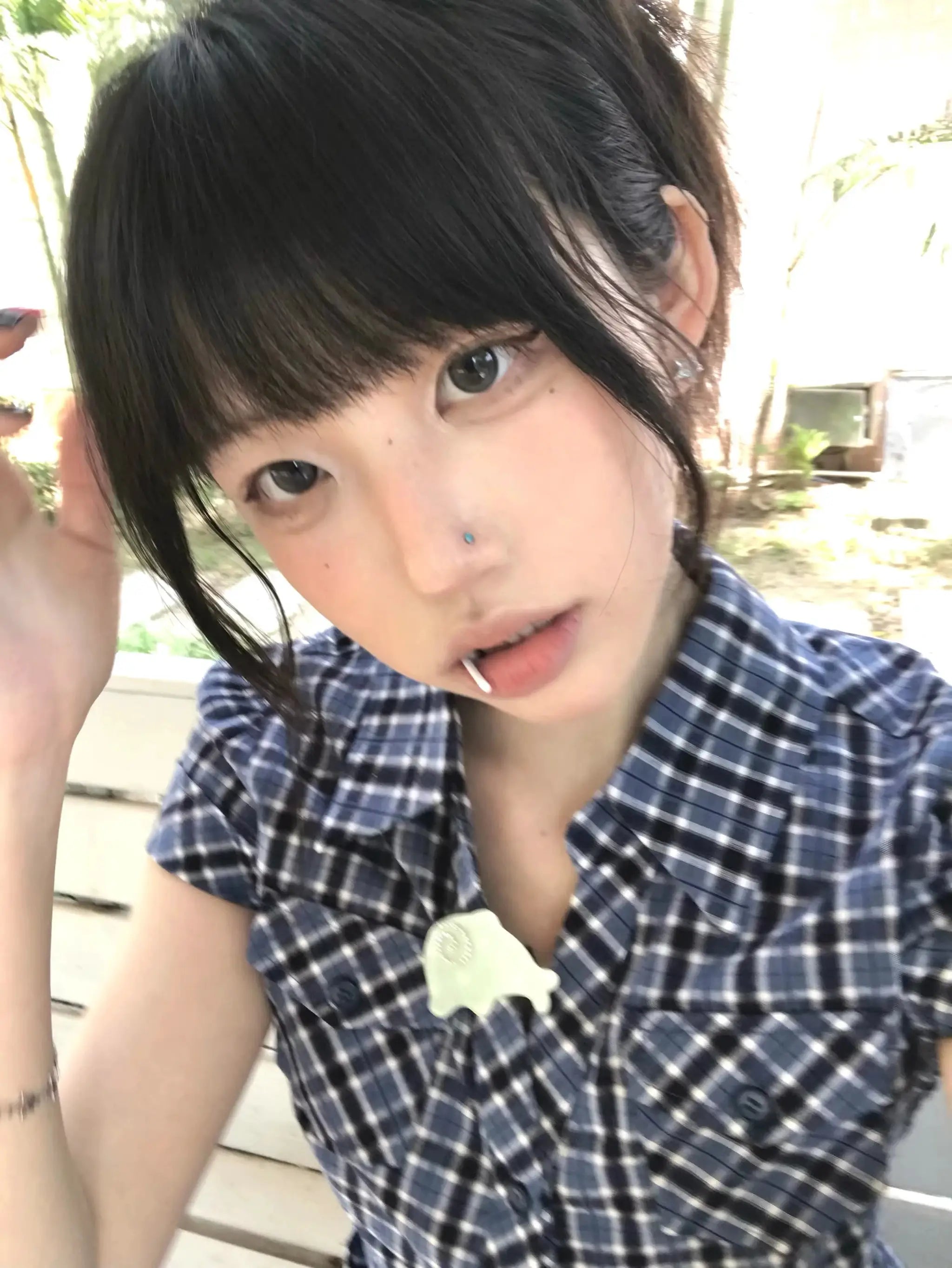 Karrram blue plaid short-sleeve shirt worn by a woman; navy check pattern with buttons