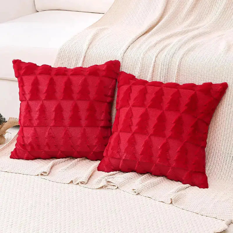 2 red tufted decorative throw pillows on a cream sofa with a knit blanket