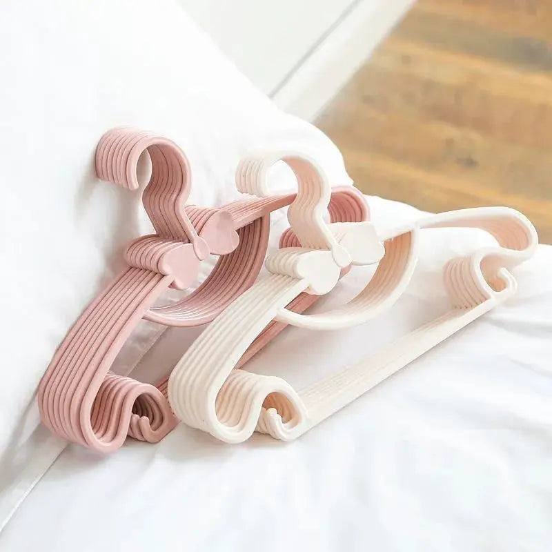 Baby clothes hangers, set of four, pastel pink and white plastic, for scarves, towels, and coats