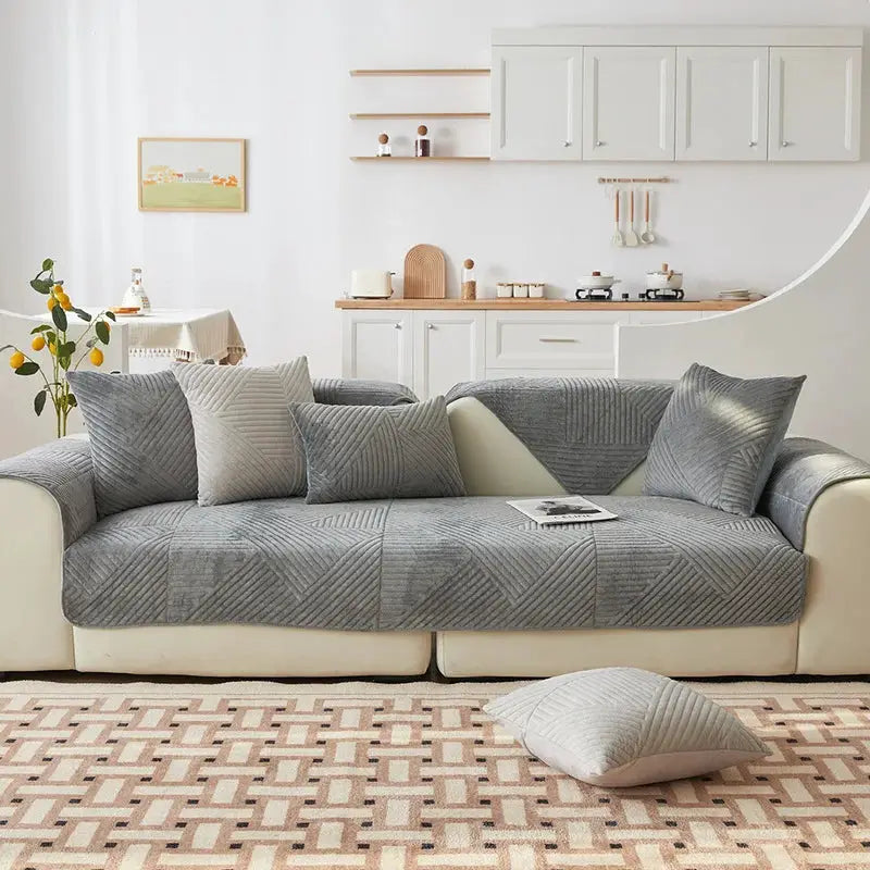 Crystal Velvet Sofa Cover non-slip on gray sofa with matching cushions and a floor pillow in a bright modern living room