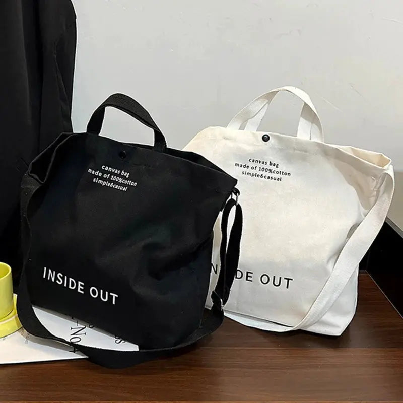 Two Simples Market canvas crossbody bags in black and cream, large-capacity totes with long straps.