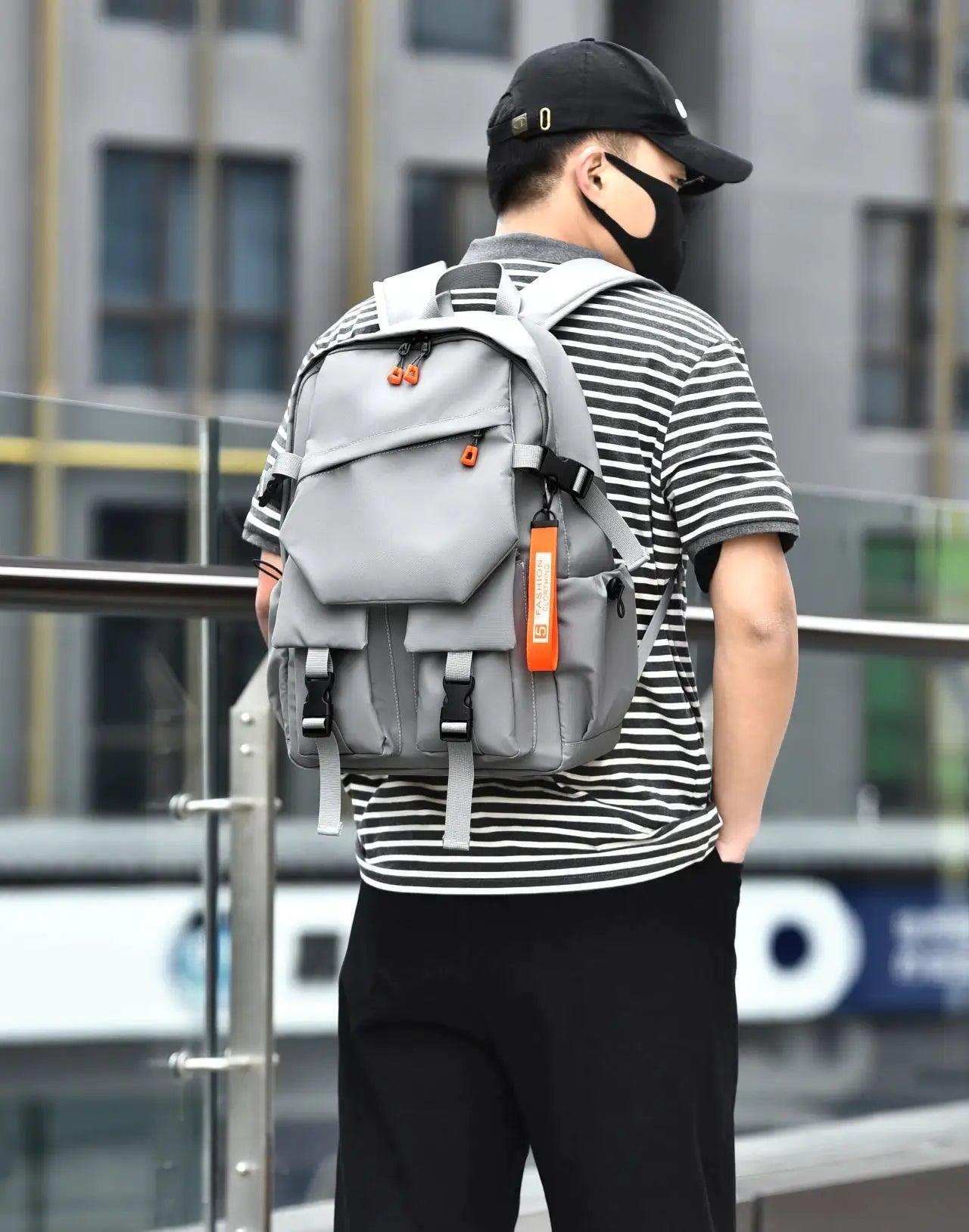 Men's gray laptop backpack with orange zipper pulls and multiple pockets.