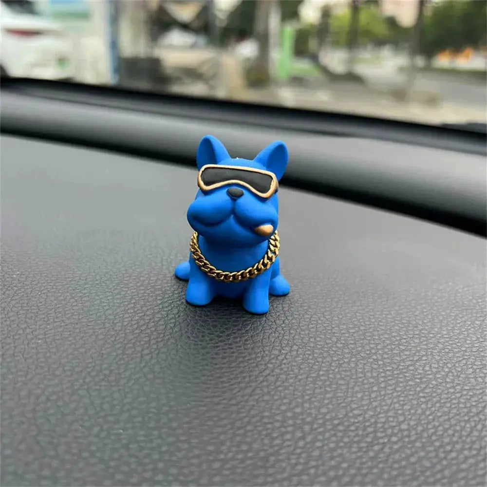 Bulldog car ornament in blue resin with sunglasses and a gold chain on dashboard
