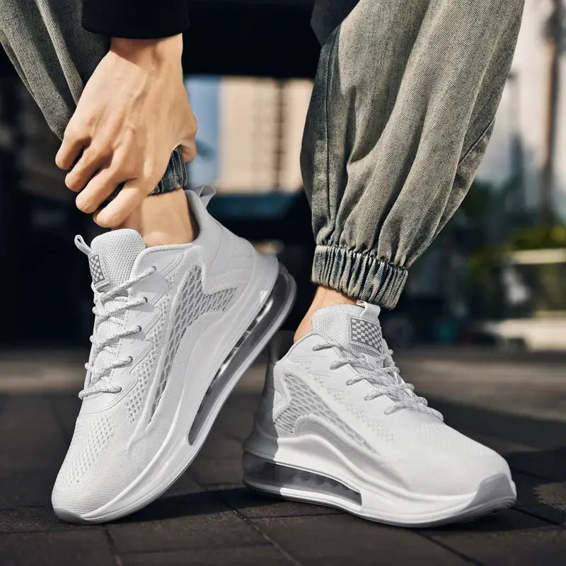 Pair of men's white sneakers with breathable knit upper and air-cushioned sole.