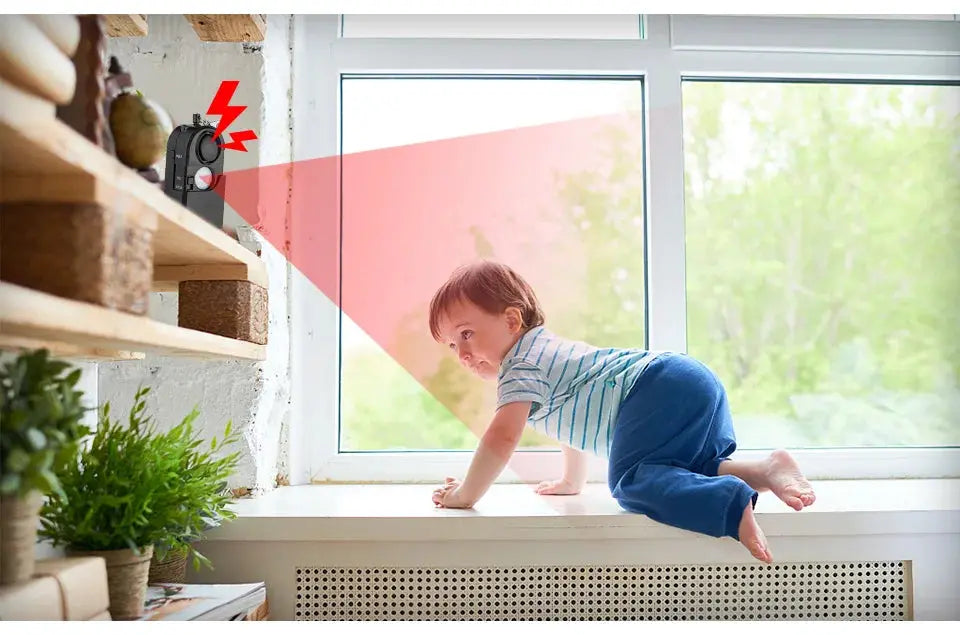 KERUI portable mini motion detector alarm, black device with a red warning beam by a window near a crawling toddler.