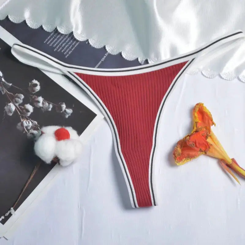 Women's red thong underwear with white-black striped trim; seamless low-waist G-string.