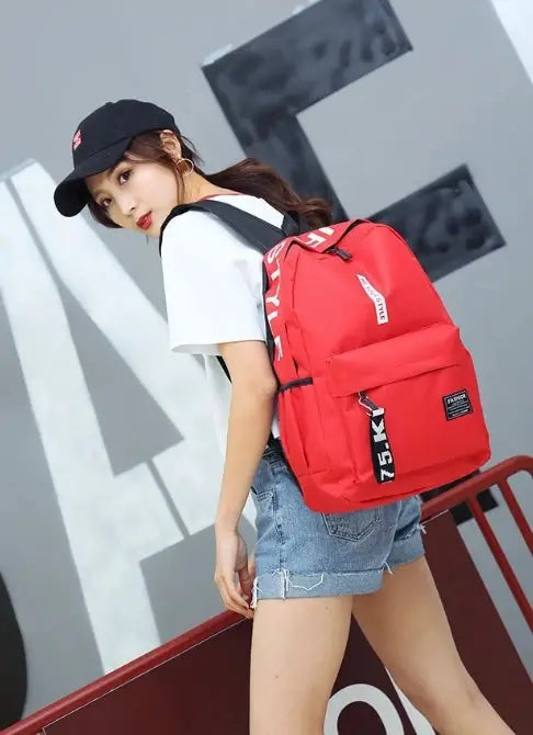 Backpack, red unisex school bag with large capacity worn by a woman in casual outfit.