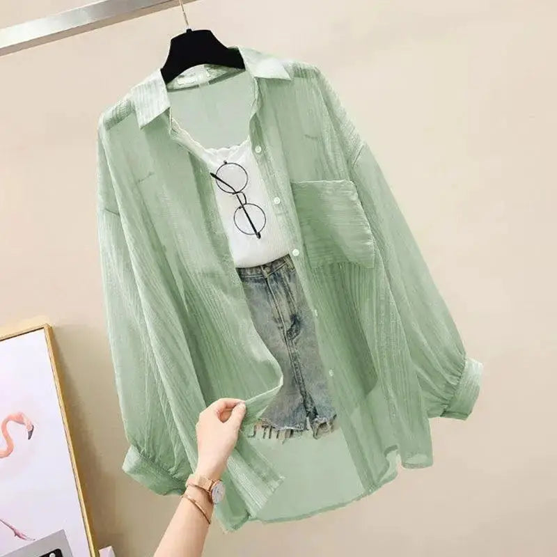 Mint green chiffon blouse, see-through, loose-fit with collar and pocket, worn over white tee and denim shorts.