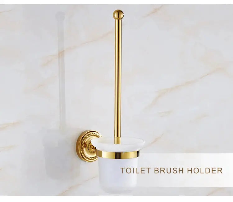 Gold brass toilet brush holder with white ceramic cup on a wall mount.