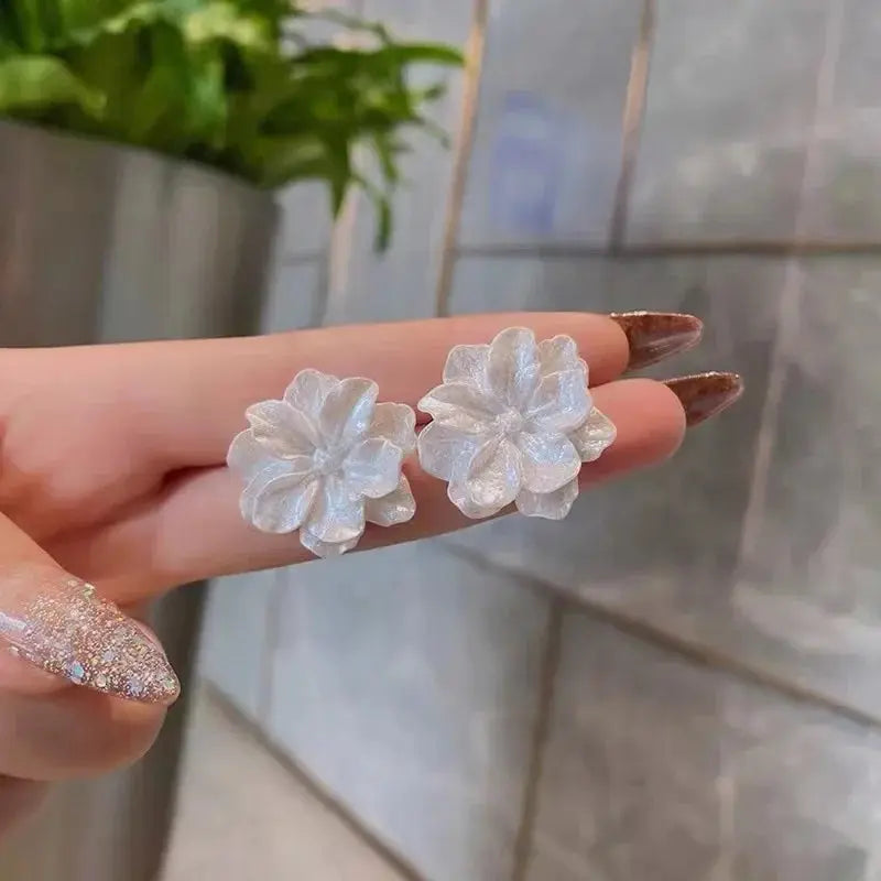 White flower stud earrings pair with pearl-like petals, camellia style.
