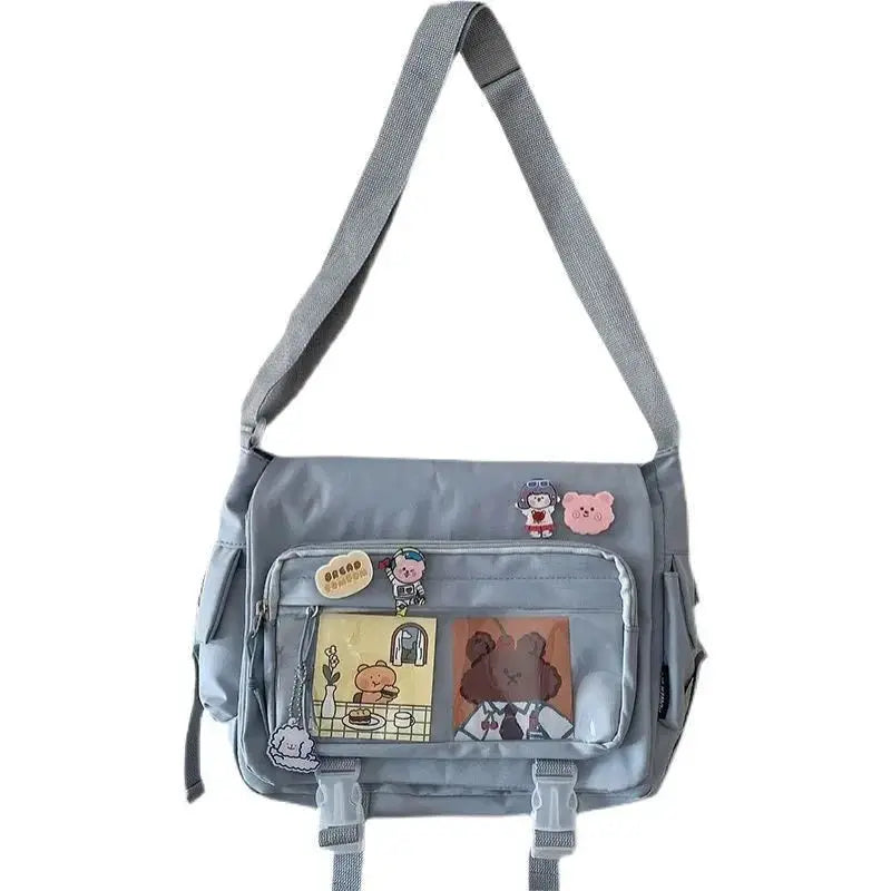 Large capacity canvas crossbody bag by Simples Market in light blue with front zip pockets and decorative patches