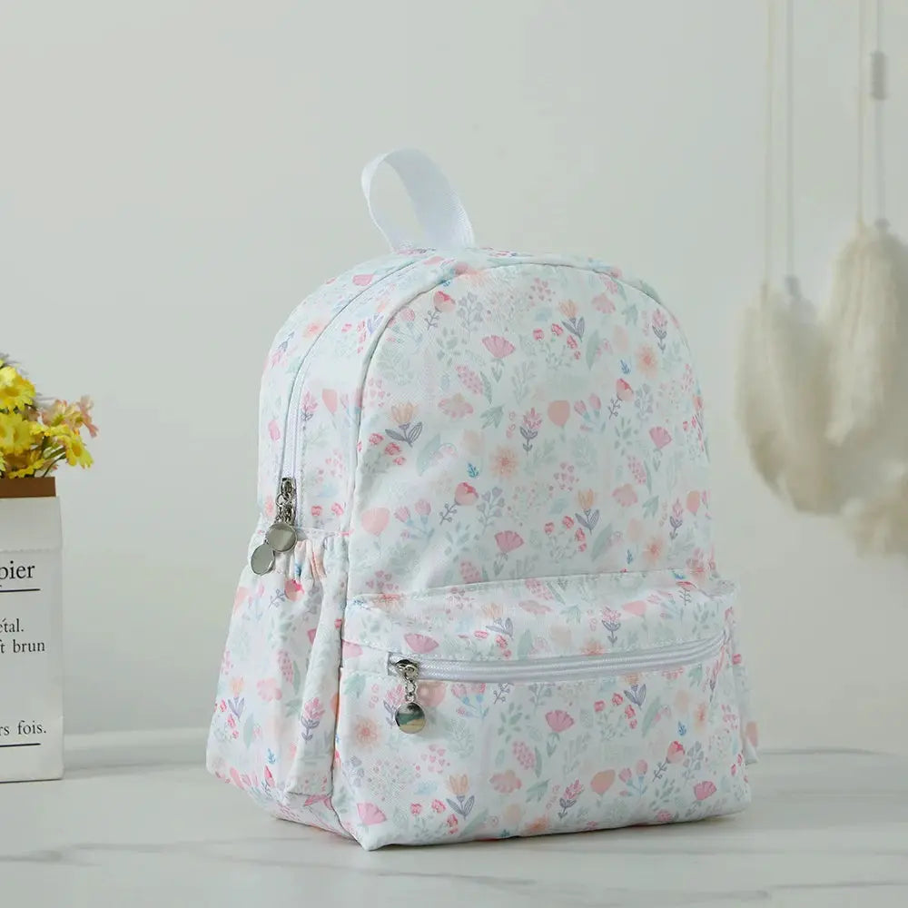 Toddler backpack floral print in pastel white with pink and blue flowers, front pocket, lightweight