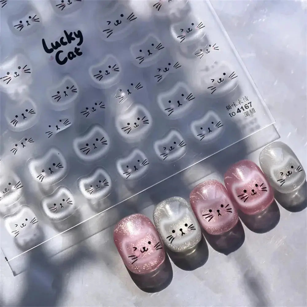 Cat face nail art decals sheet with white Lucky Cat designs; pearlescent pink and pearl manicures shown