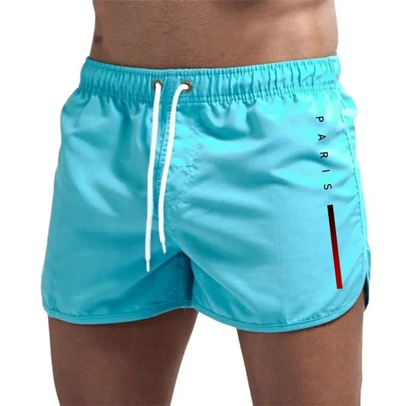 Simples Market men's turquoise board shorts with white drawstring and PARIS stripe graphic