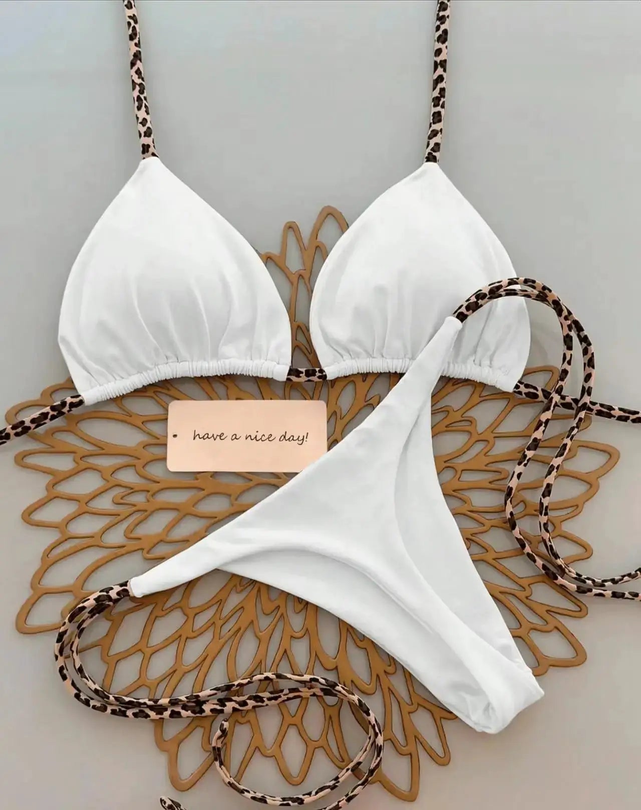 Simples Market white bikini set with leopard-print straps, triangle cups, and thong bottom