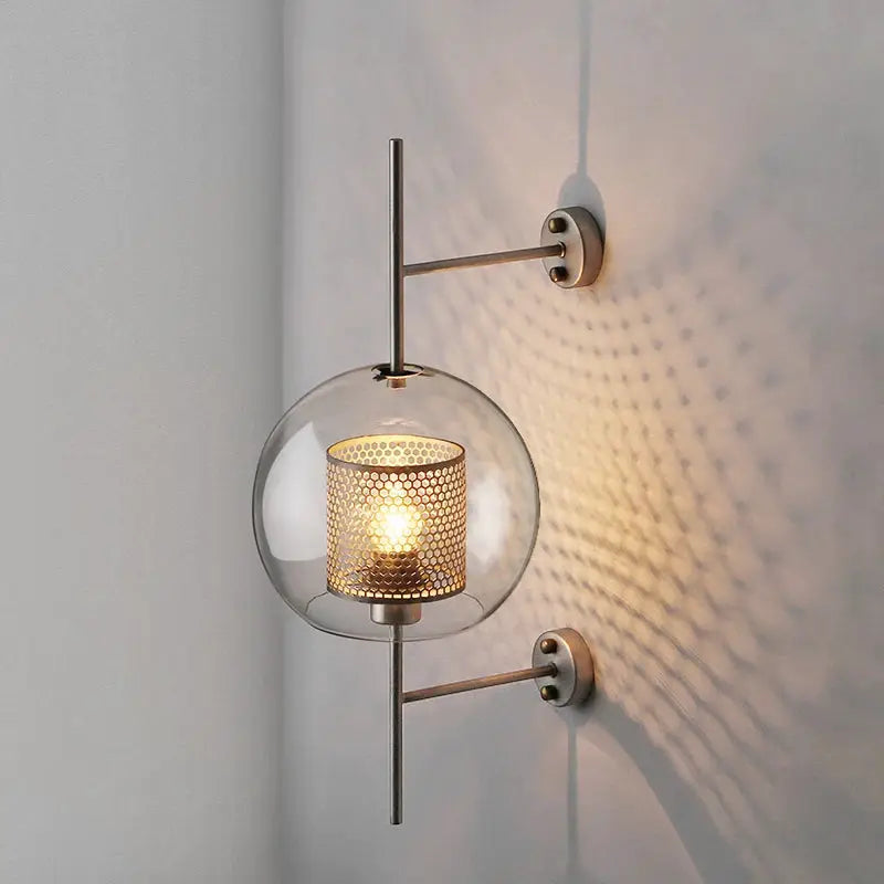 Simples Market modern glass wall lamp with clear globe and golden perforated inner shade, warm glow
