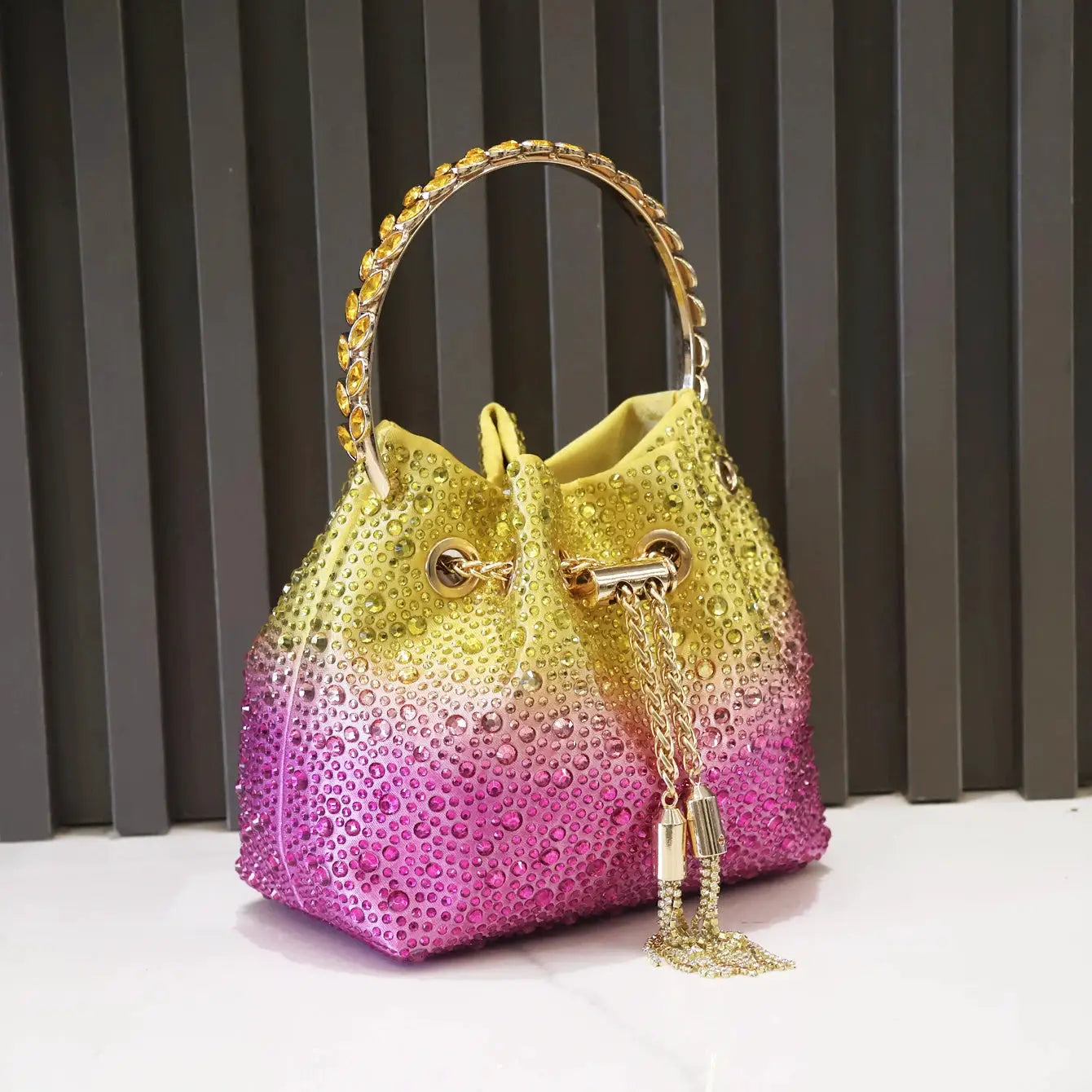 Rhinestone gradient evening clutch by Simples Market with a gold-tone jeweled handle; yellow-to-pink bucket bag