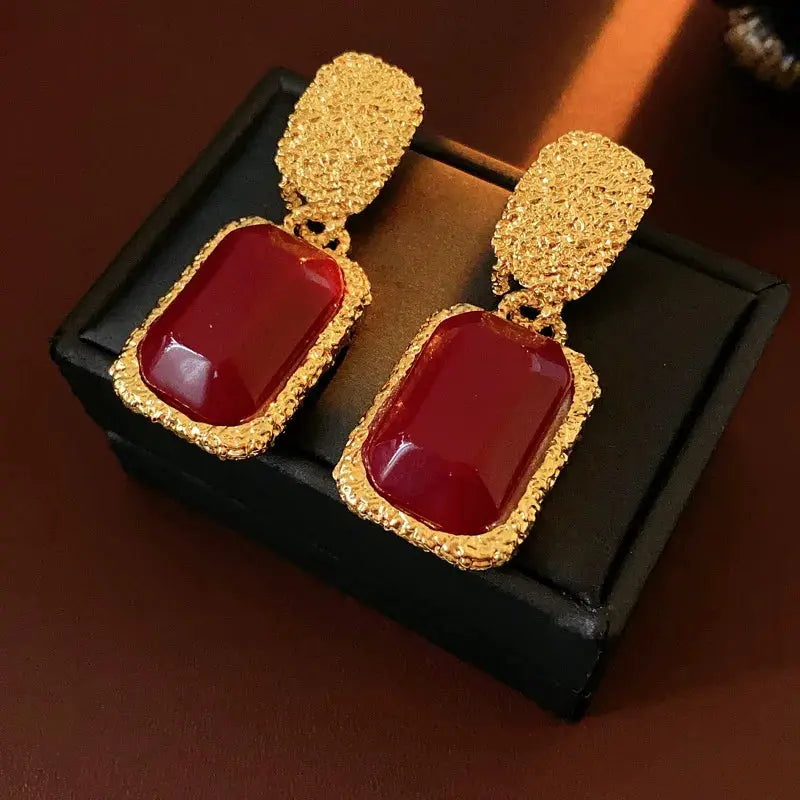 Pair of vintage red resin earrings with gold-tone textured frames and top oval studs