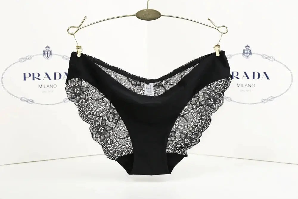 Black lace low-rise panties with floral side panels on a hanger; Prada backdrop