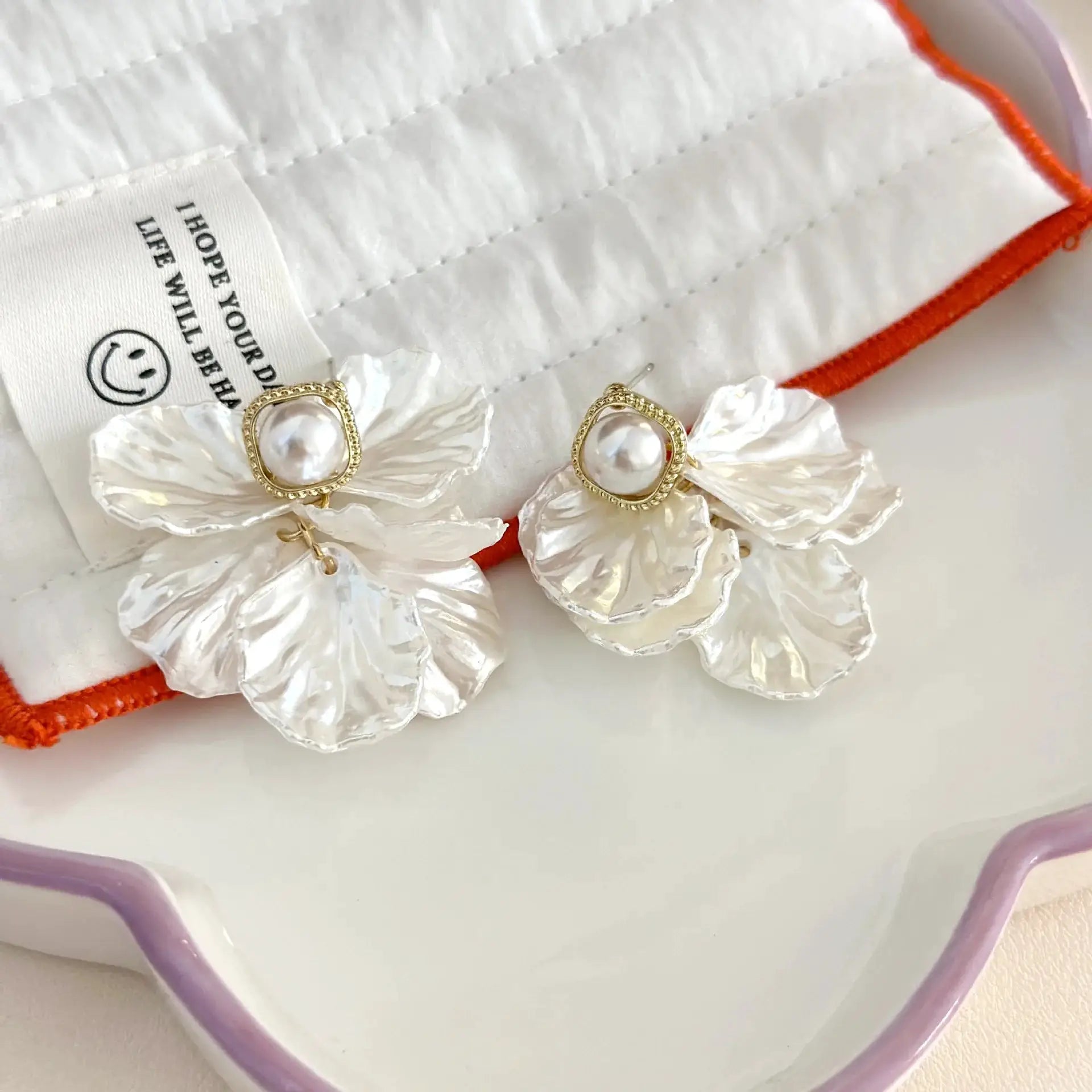 Pair of shell flower pendant earrings with glossy pearl centers in gold-tone frames for women