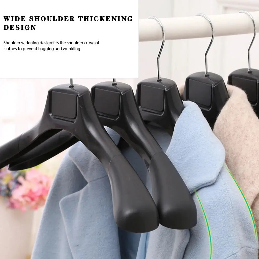 5-pack wide-shoulder black plastic coat hangers with blue and beige coats on a wardrobe rod