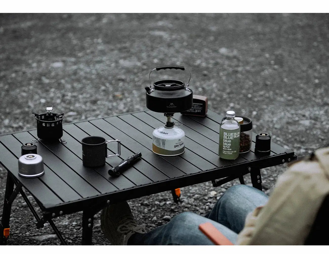 MK-3000W mini portable camping gas burner on a white gas canister with kettle on a folding table