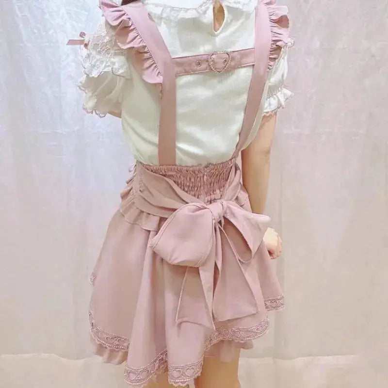 Gothic Lolita pink ribbon suspender skirt with a large back bow and lace-trimmed hem