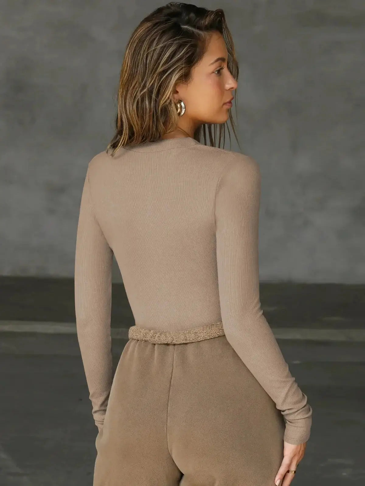 Beige knit jumpsuit with textured belt, long sleeves, back view