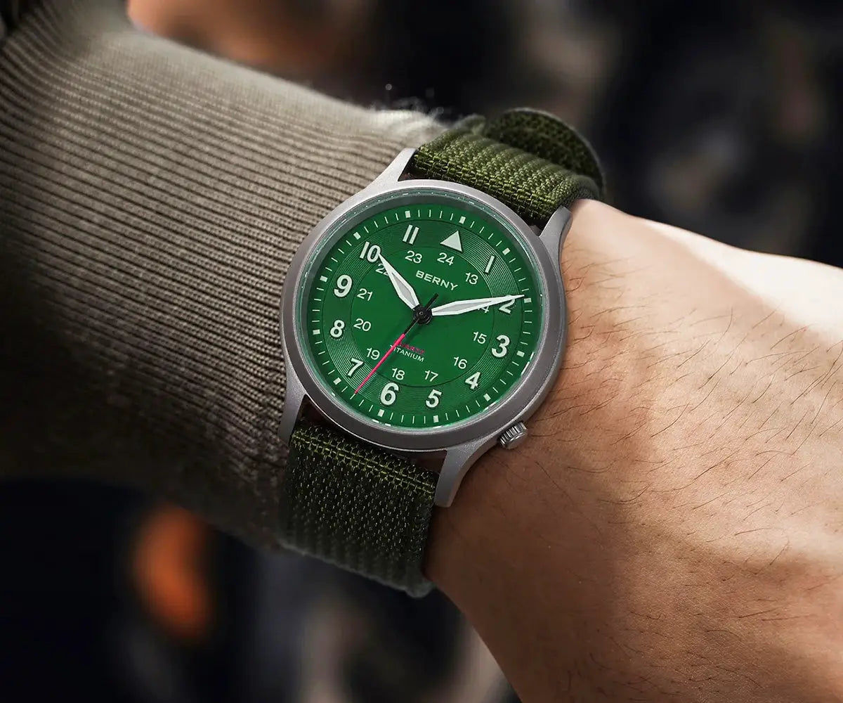 BERNY titanium field watch for men with green dial, white numerals, and green fabric strap on a wrist.
