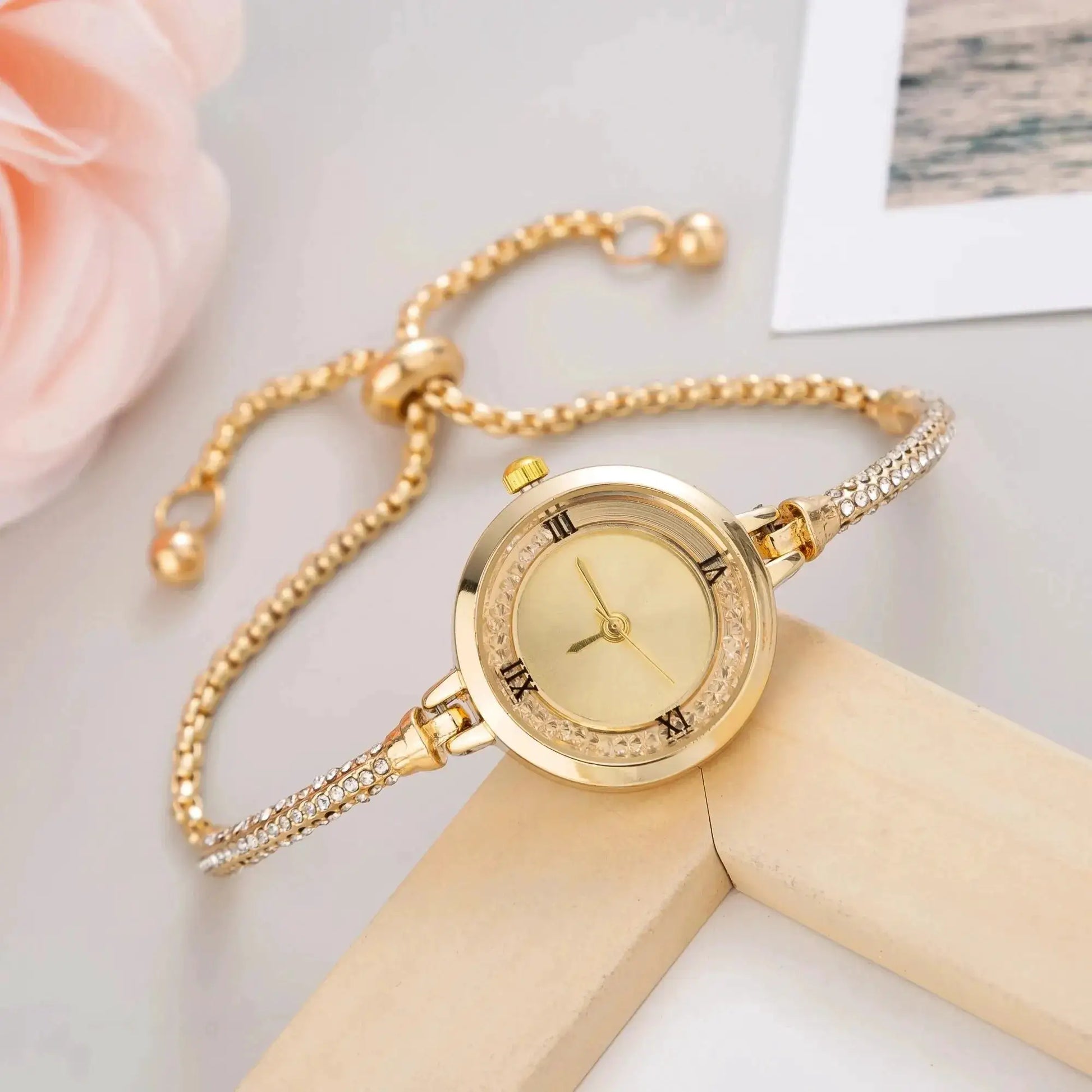 Women's gold wristwatch with crystal-studded bezel and linked bracelet