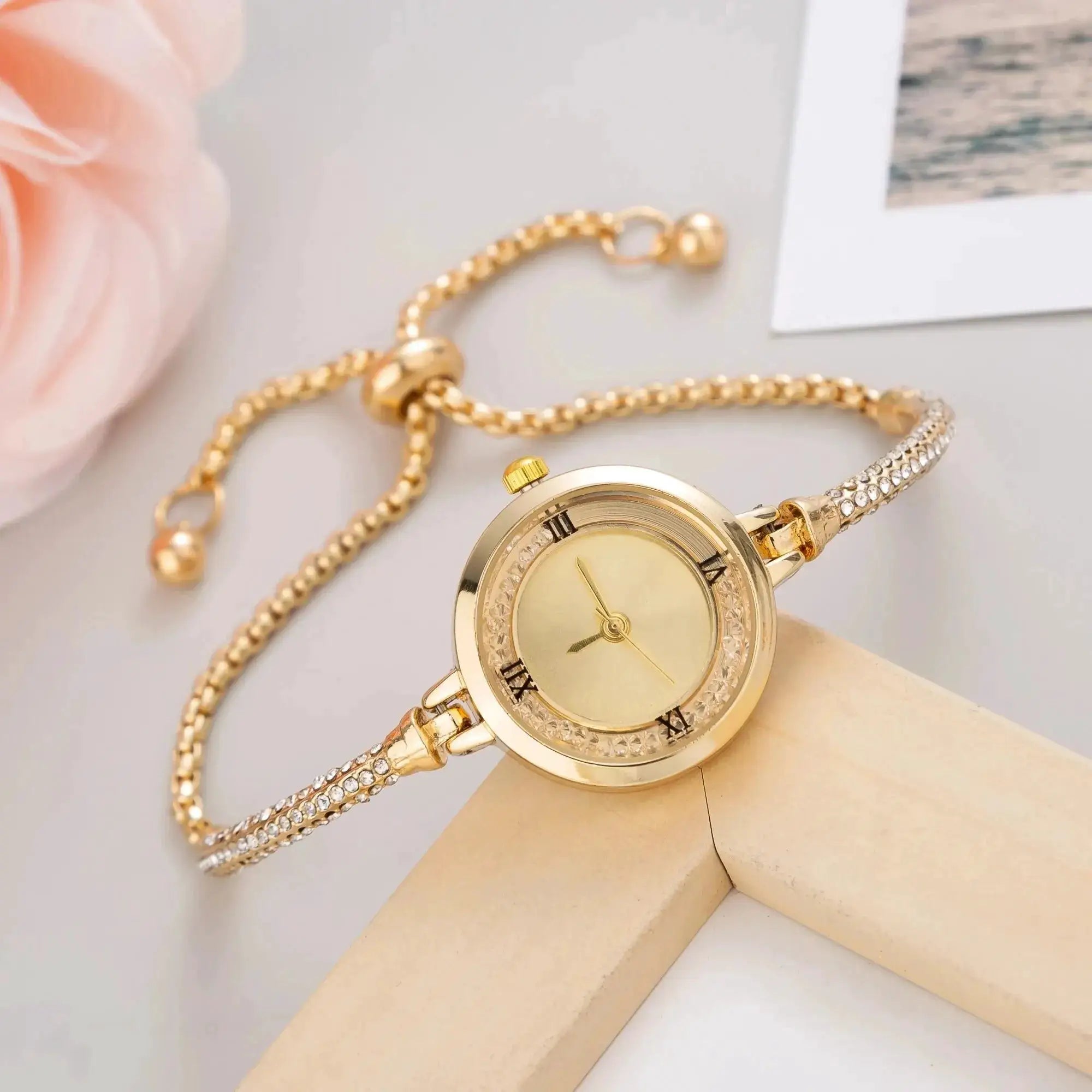 Women's gold wristwatch with crystal-studded bezel and linked bracelet