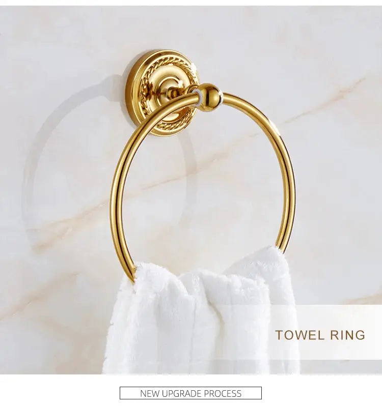 Towel ring in gold brass mounted on a marble wall with a white towel