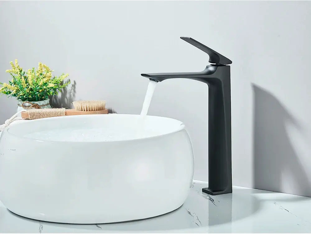 Matte black deck-mounted bathroom faucet with single lever over a white round sink.