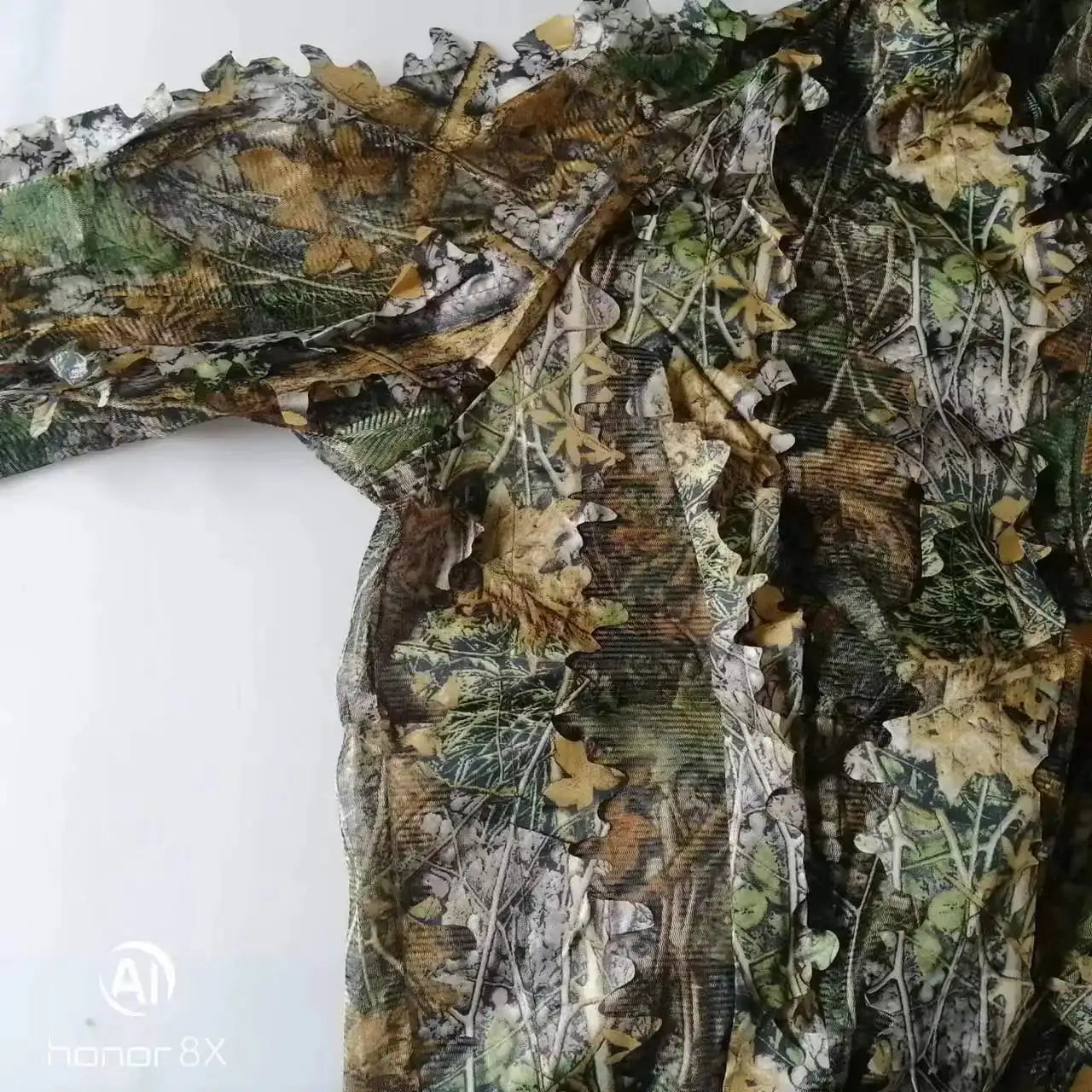 Ghillie camouflage suit for men and women with hooded jacket and pants, leafy jungle pattern.
