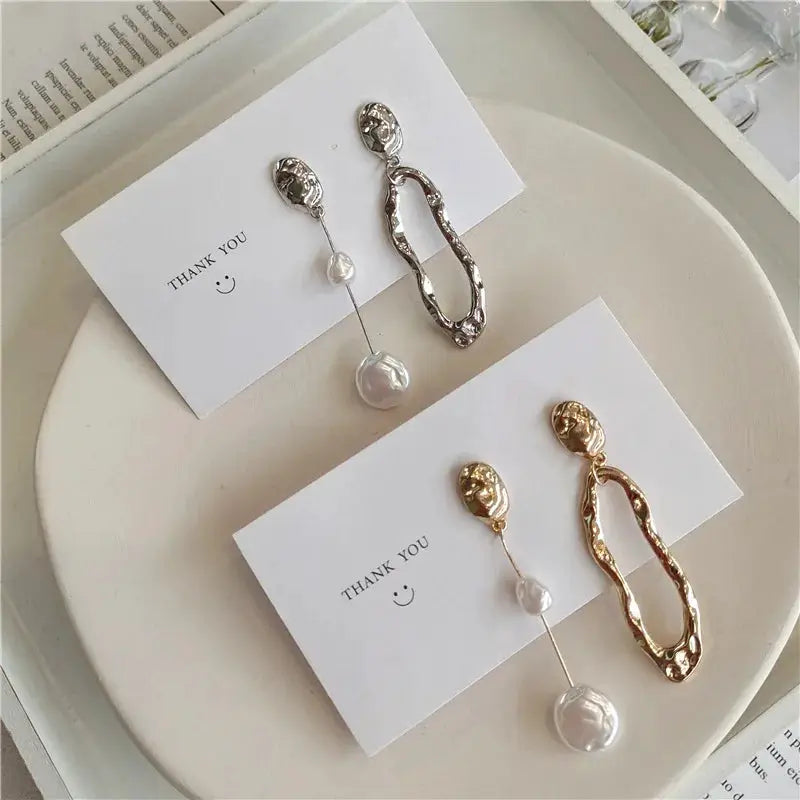 Irregular pearl drop earrings, two pairs by Simples Market, silver and gold-tone with long wavy loops